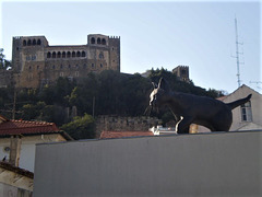 Cat sculpture with the castle's gallery on the background.