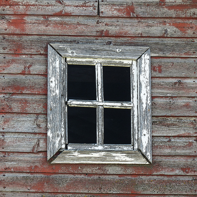 Weathered window from the smaller red barn