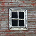Weathered window from the smaller red barn