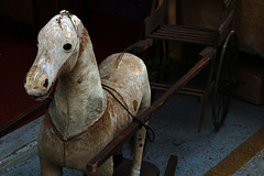 Aux Puces de Saint-Ouen , un cheval à bascule recouvert d'une peau de vachette .......
