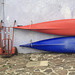 A white wall, a red and a blue canoe.