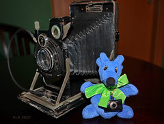 Maskottchen Ratty vor einer "Patent Etui" -Kamera