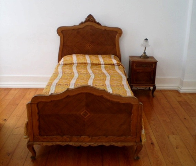 Single bed and bedside table of the poet Fernando Pessoa.