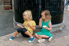 Deux pauvres fillettes abandonnées mangeant une glace sur un trottoir