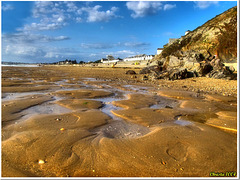 Structures de sable scintillantes à marée basse.
