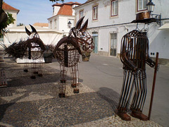 Sculpture of man leading donkeys.