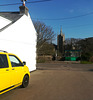 Yellow (van), white (wall), blue (sky) and green (bus stop)