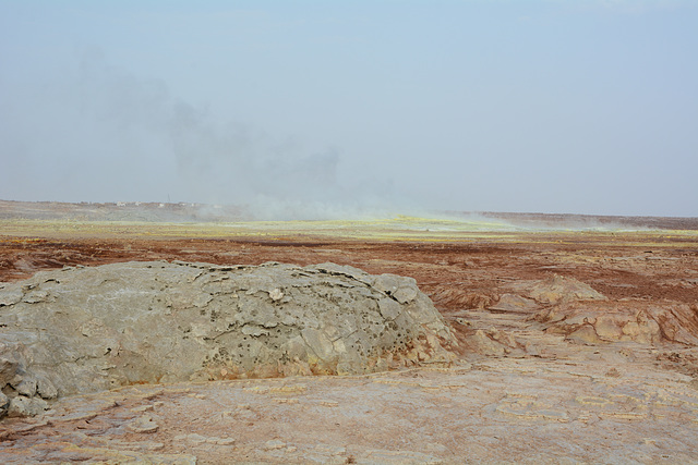 Ethiopia, Danakil Depression, The Crater of Dallol Volcano with Sulfur Gas Outlets and Dallol Settlement behind.