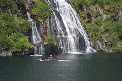 Norway, Lofoten Islands, Kayakers at the Trollfjord Waterfall