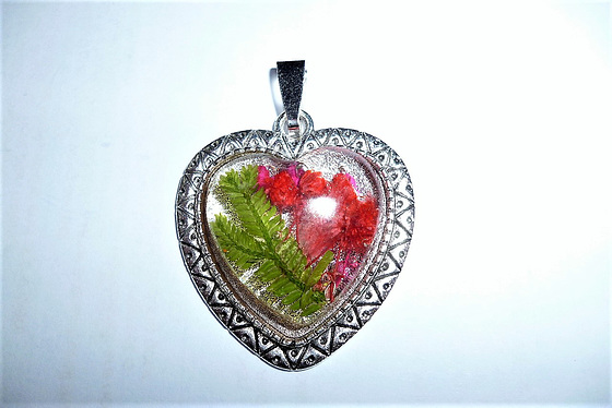 Heart-shaped pendant with red flowers.