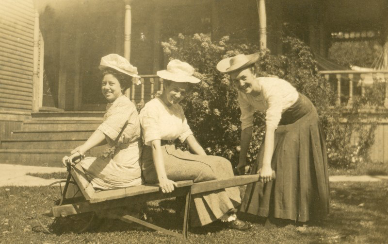 Three Women with Hats and a Wheelbarrow