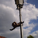 Bronze dwarf - acrobat on lamp pole.