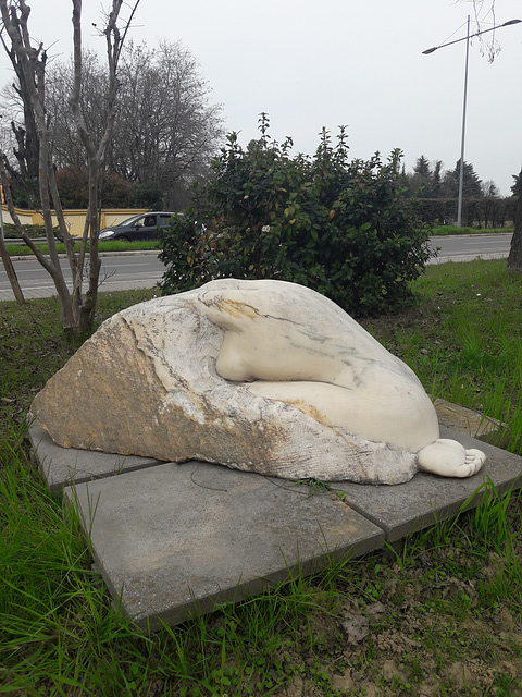 Un  ragazzo artista sta scolpendo una donna dormiente sul marmo che ha portato nella strada di casa!