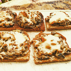 Geröstetes Vollkorn-Toast mit angebratenen Champions, Zwiebeln und Creme Fraiche, überbacken mit Mozzarella