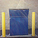 Blue box with yellow posts and fractured sunlight