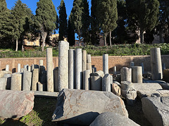 Roman columns in front of a wall.