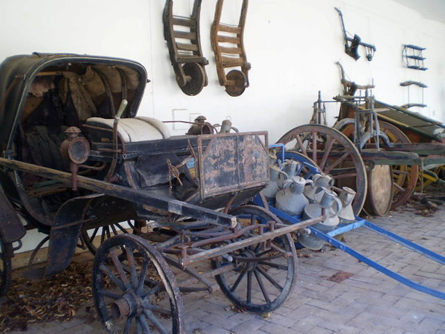 Horse-drawn landau and load wagon.