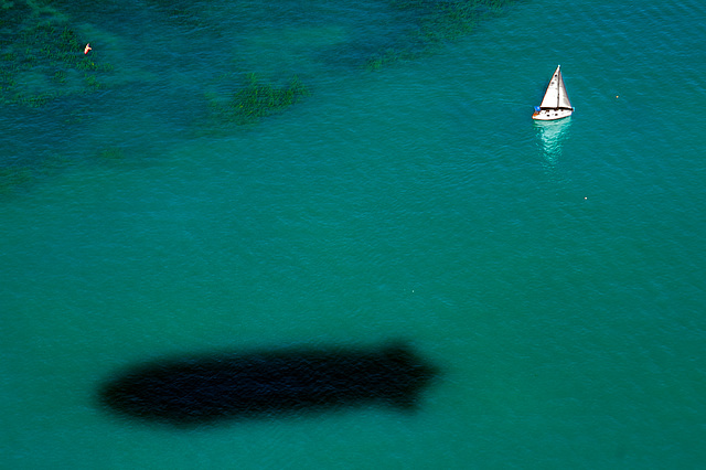 Lonely sailingboat and the zeppelin shadow