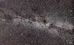The Milky Way galaxy with what looks like the path of a satellite streaking across the image - bottom right to top centre