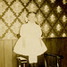 Girl Standing on a Chair in Front of Patterned Wallpaper