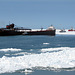 Ice breakers and tug moving a freighter