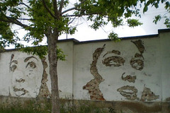 Carved murals by Vhils, on inside wall of ancient factory.