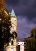 Gebäude mit Spitzdach vor bedrohlichen Regenwolken