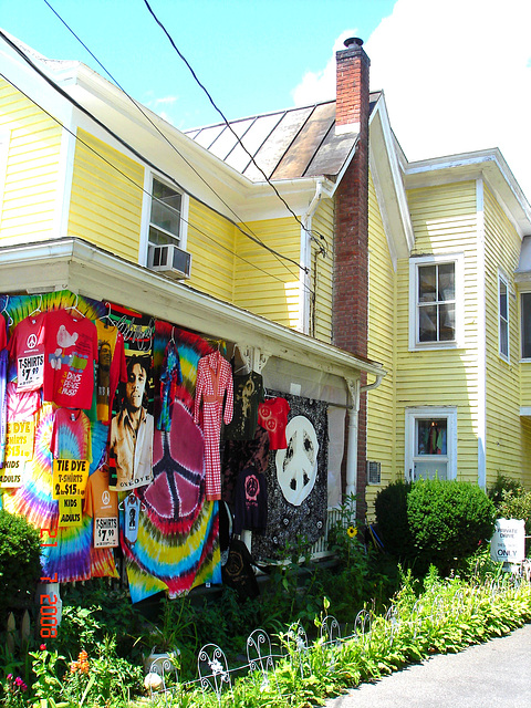 Colourful t-shirts display with a typical american house