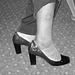 Black Lady in black & red hammer heels -  Noire sexy en beaux souliers à talons hauts rouge & noir - Avec permission / With permission - Aéroport de Bruxelles.- Noir et blanc avec photofiltre