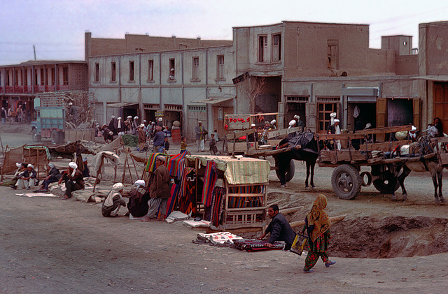 Textiles and garments are displayed on the ground