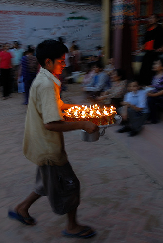 Boy brings new lighted butter lamps