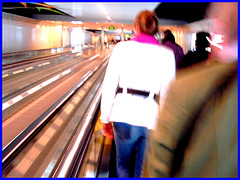 Blurry redhead in white outfit   /   Élégante Dame en blanc sur tapis mécanique -  Brussels airport.