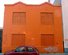 Orange building, red car.