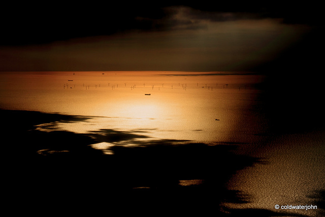 Aerial - Wind turbines in a patch of sunlight in the English Channel