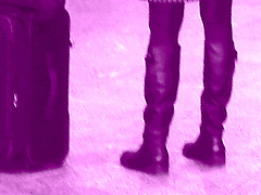 Blond in flat boots and checked skirt /  Blonde en bottes SS et jupe en damiers- Aéroport de Montréal. - Photofiltrée en violet.