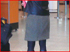 Blonde in flat boots and checked skirt /  Blonde en bottes SS et jupe en damiers- Aéroport de Montréal.