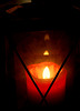 Flameto de ruĝa kandelo en lanterno