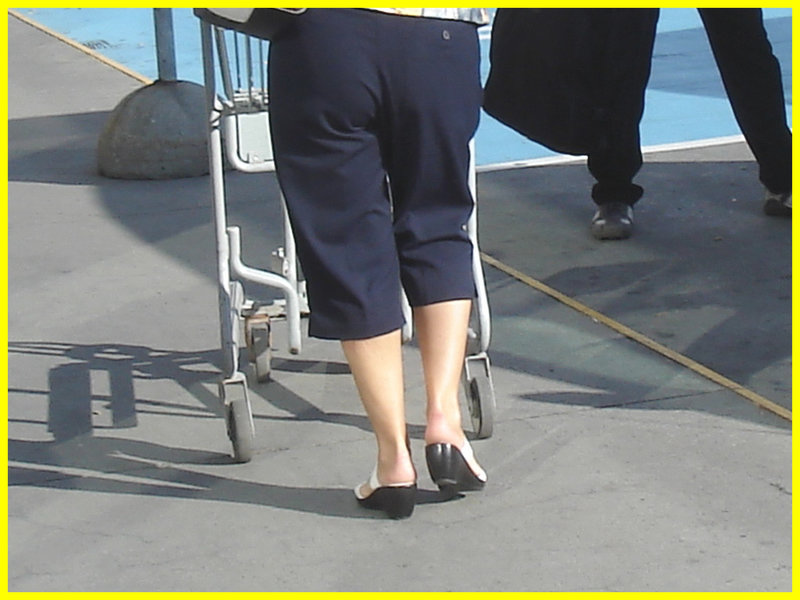 Blond mature in white sexy strappy sandals-  Dame blonde du bel âge en sandales blanches à courroies -  Aéroport de Montréal.