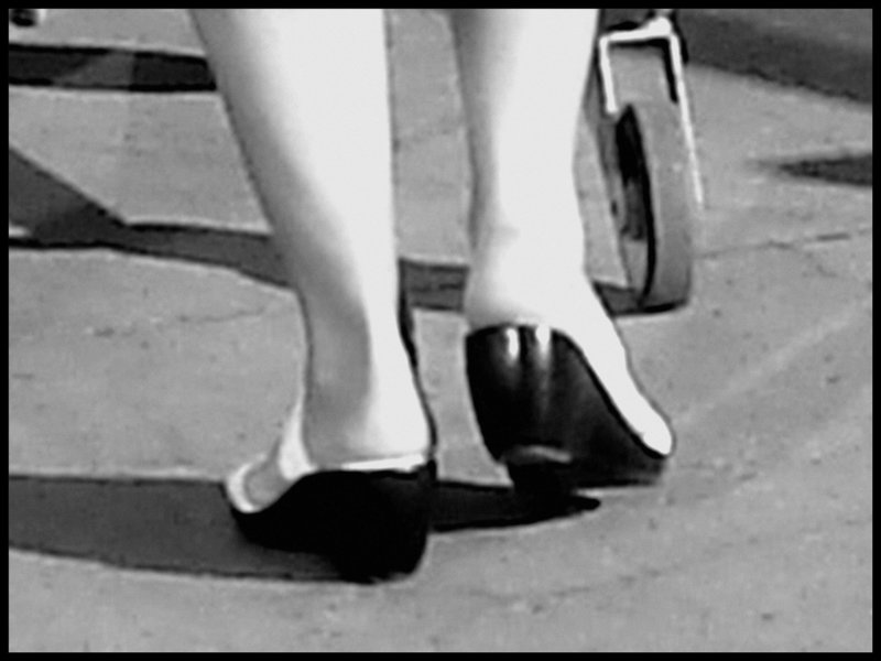 Blond mature in white sexy strappy sandals-  Dame blonde du bel âge en sandales blanches à courroies -  Aéroport de Montréal- Photofiltre en noir & blanc.