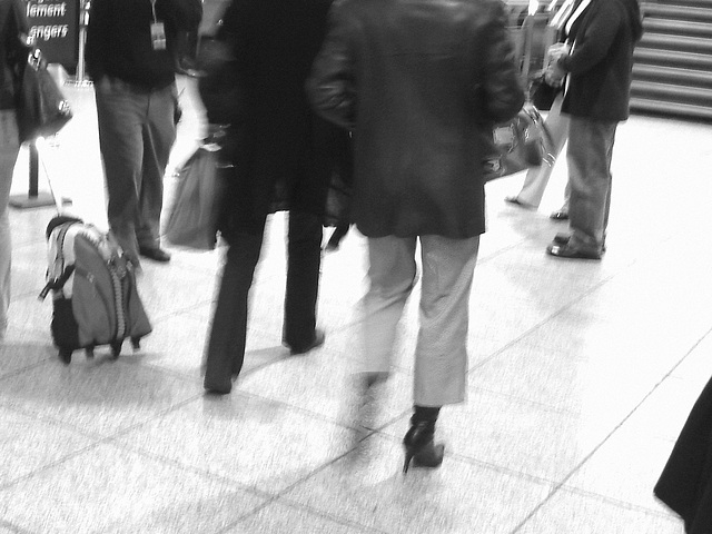 Bottes à talons aiguilles et jambe tremblante - Stiletto Boots and trembling leg -  Pet Montreal airport .-  Photofiltered in Black & white.