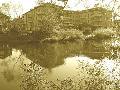 Apartments building and rowboat by the river /  Édifice à appartements avec chaloupe et canards -  Ängelholm / Suède.  23 octobre 2008 - Sepia
