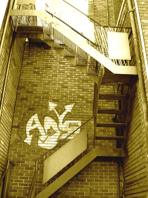 Escaliers de secours et graffiti sur mur de briques /  Fire escape and bricks wall hometown graffiti / Sepia