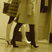 Duo sexy en bottes à talons aiguilles /  Sexy duo in stiletto heeled boots -  Aéroport de Montréal / Montreal airport.  15 novembre 2008  -  Talons aiguilles sur plancher luisant - Sepia