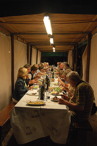 Rondo familia en vespera manĝo en la bela regiono Toskano en Italio.
