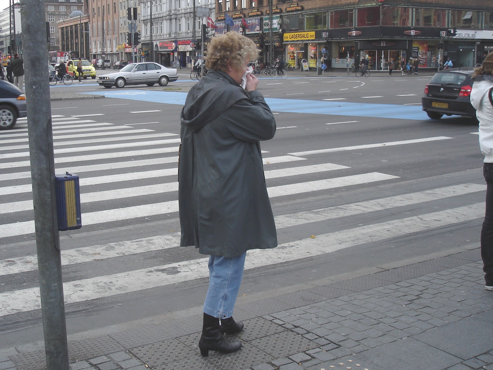 Street corner curly Mature Lady in sexy high-heeled boots and jeans /  Dame mature aux cheveux bouclés en bottes à talons hauts et jeans