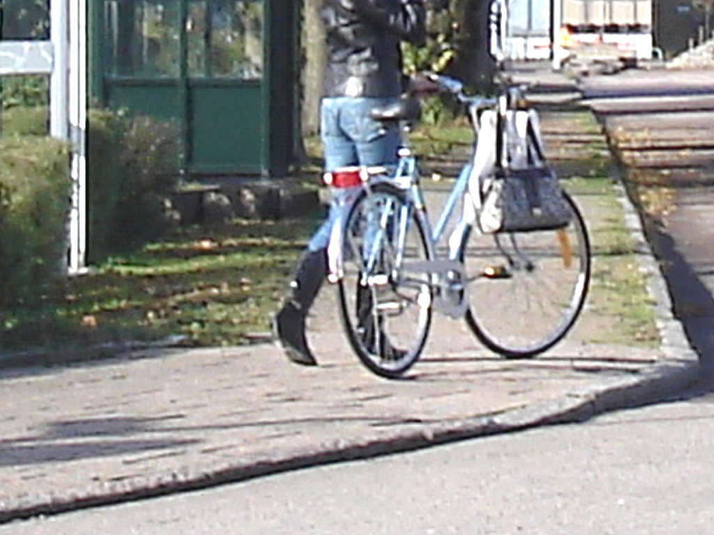 Cycliste en bottes à talons hauts / Walking Swedish biker in jeans & high-heeled boots at her cell phone - Ängelholm  / Suède - Sweden.  23-10-2008