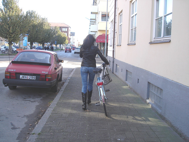 Cycliste en bottes à talons hauts / Walking Swedish biker in jeans & high-heeled boots at her cell phone - Ängelholm  / Suède - Sweden.  23-10-2008