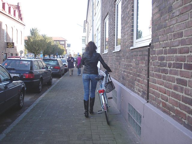 Cycliste en bottes à talons hauts / Walking Swedish biker in jeans & high-heeled boots at her cell phone - Ängelholm  / Suède - Sweden.  23-10-2008