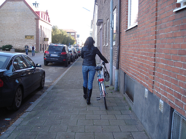 Cycliste en bottes à talons hauts / Walking Swedish biker in jeans & high-heeled boots at her cell phone - Ängelholm  / Suède - Sweden.  23-10-2008