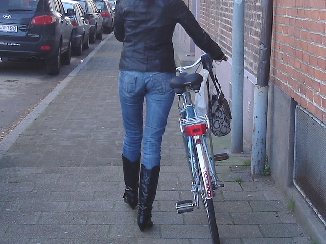 Cycliste en bottes à talons hauts / Walking Swedish biker in jeans & high-heeled boots at her cell phone - Ängelholm  / Suède - Sweden.  23-10-2008